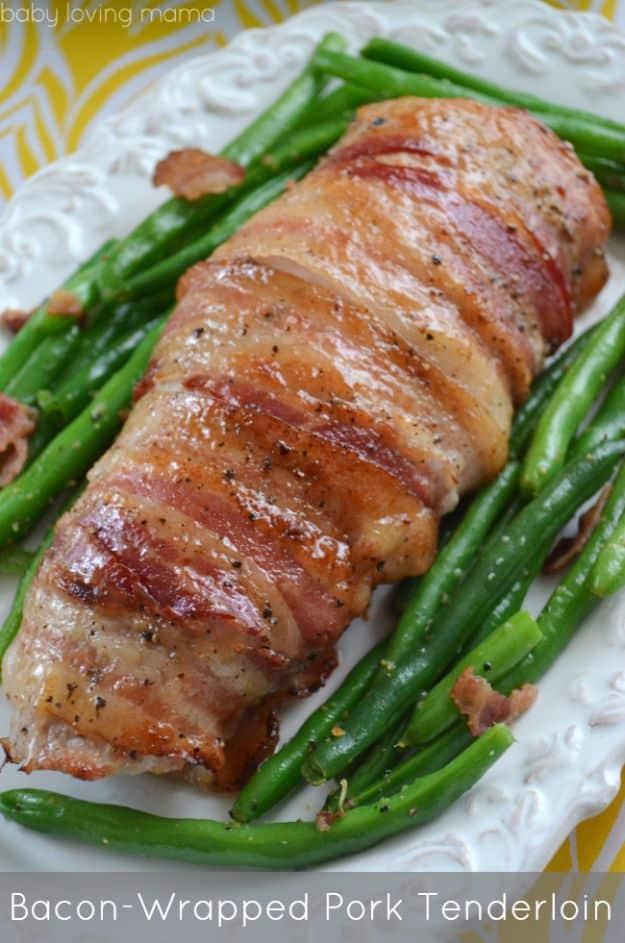 Bacon wrapped pork tenderloin for Easter dinner, glazed and whole on a white platter with green beans