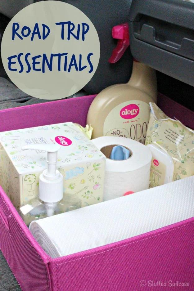 Road trip essentials packed in a pink fabric trunk bin with paper towels, toilet paper, tissues and hand soap
