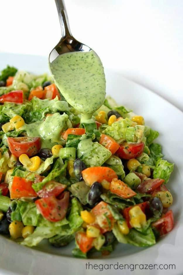 Southwestern chopped salad on a white plate with romaine, black beans, corn, tomatoes and green dressing
