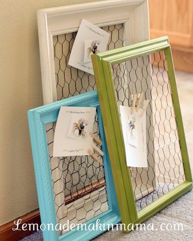 A stained wooden frame strung with chicken wire holds photos and cards clipped on with tiny wooden clothespins