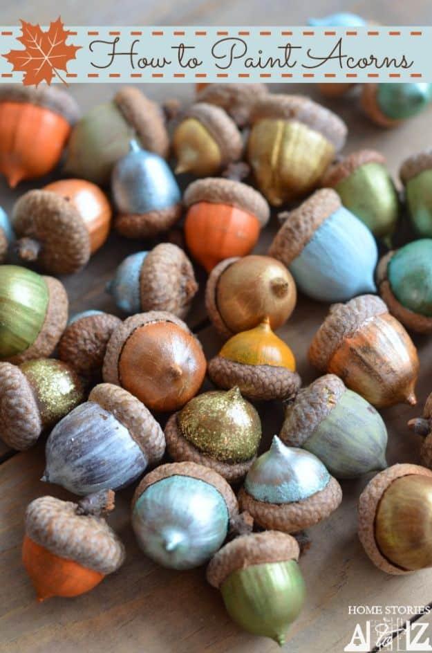 Pin graphic reading How to Paint Acorns, a pile of acorns painted in green, blue, orange and gold with caps on