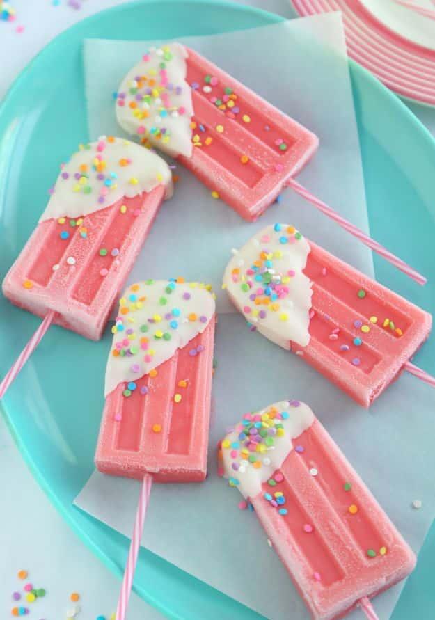 Strawberry milk ice pops dipped in white chocolate and pastel confetti sprinkles on a tray, a nostalgic frozen summer snack