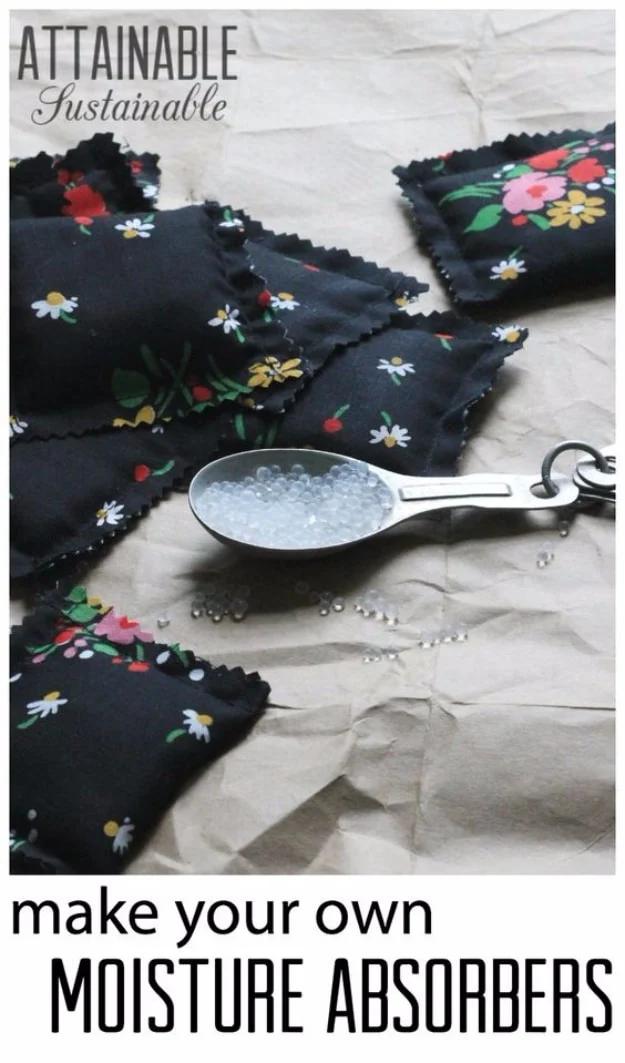 Black floral print fabric packets of homemade desiccant scattered on brown paper with a spoonful of silica beads