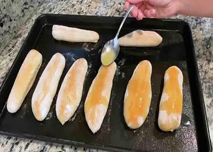 Brushing some melted butter to the breadsticks