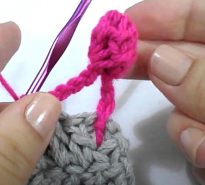 Make a crochet border with pom poms