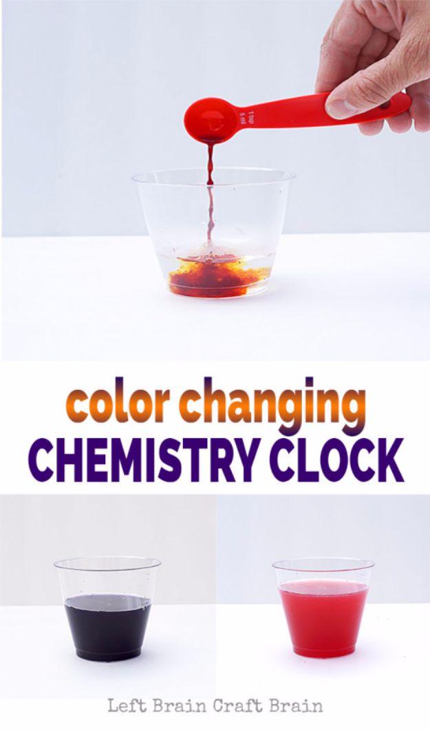 Color changing chemistry clock, a hand pouring red liquid from a measuring spoon into a cup, above dark blue and red cups