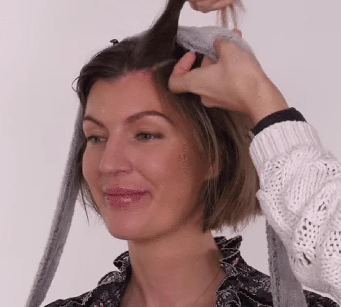 Easy heatless hair curling hack in progress, damp hair wrapped around a soft tool with no curling iron