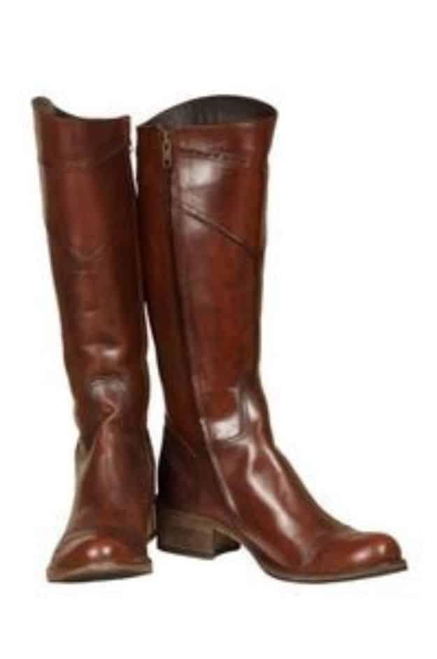 Patch leather boots, a pair of tall brown leather riding boots with buckled ankle straps on a plain white background