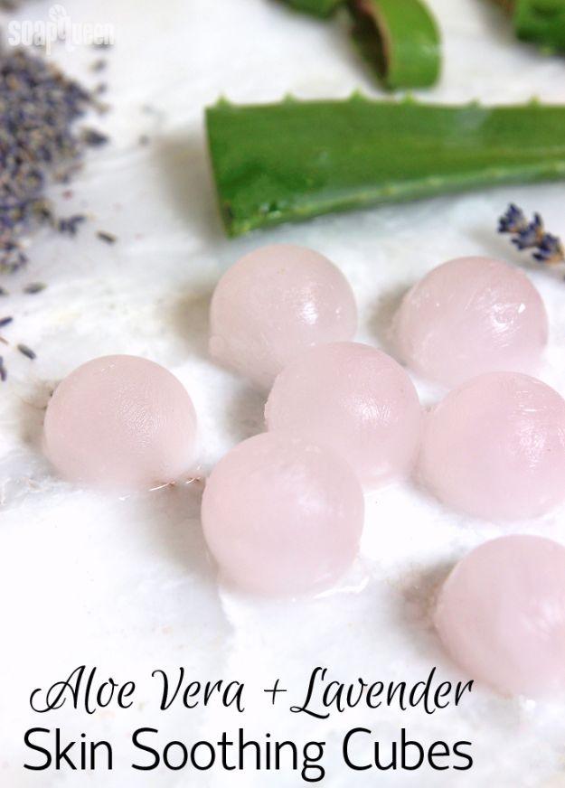 Pale pink round aloe vera and lavender ice cubes on white with a cut aloe leaf and dried lavender buds