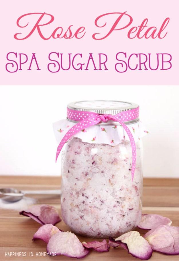 Rose petal spa sugar scrub in a pint mason jar with a pink ribbon and dried rose petals on a wood table