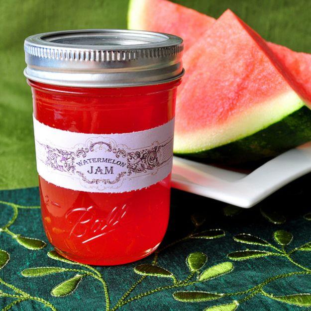 Watermelon jam in a labeled half pint Ball jar with bright pink set jam beside fresh watermelon slices