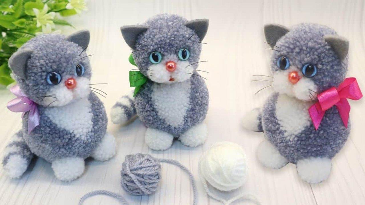 Easy DIY yarn kitten, three fluffy grey and white yarn kittens with blue eyes and ribbon bows beside balls of yarn
