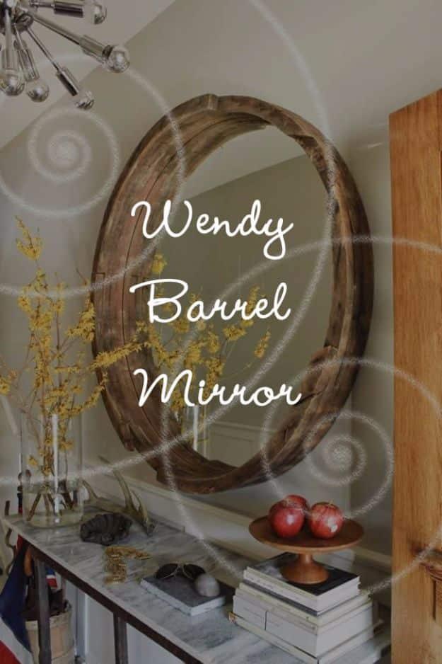 Wine barrel mirror, a large round mirror framed in weathered oak barrel staves hanging above a marble console table