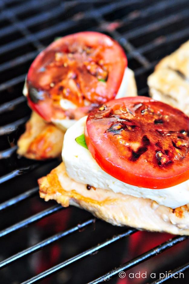 Caprese grilled chicken topped with melted mozzarella, basil and tomato under a balsamic reduction at a backyard cookout