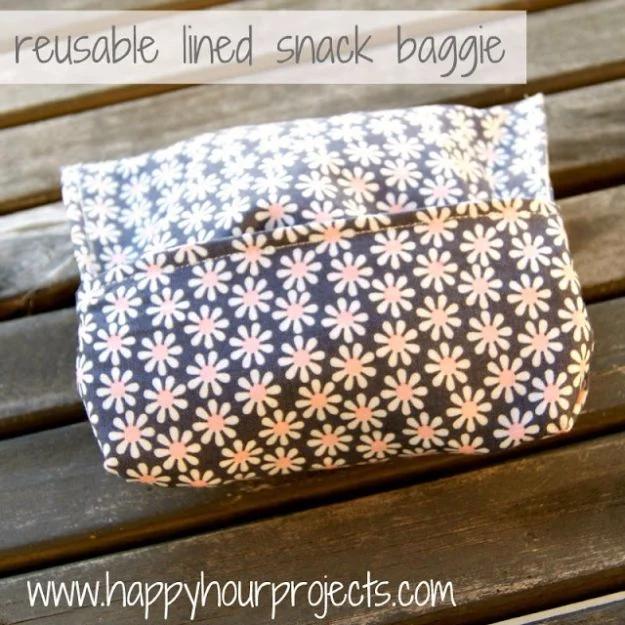 Reusable snack bag with a gray and pink daisy print fabric outside, on weathered decking under a title graphic