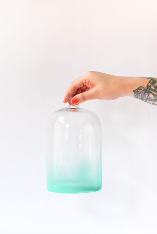 Glass cloche sprayed in an ombre fade from clear at the top to mint green at the base, held by a hand