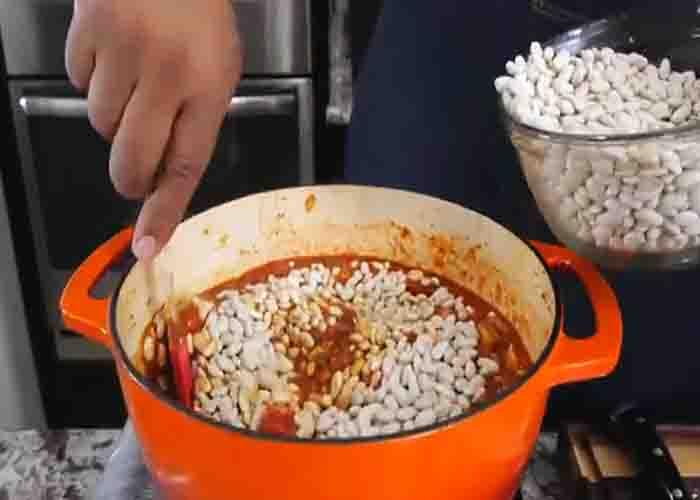 Adding the beans to the chicken chili