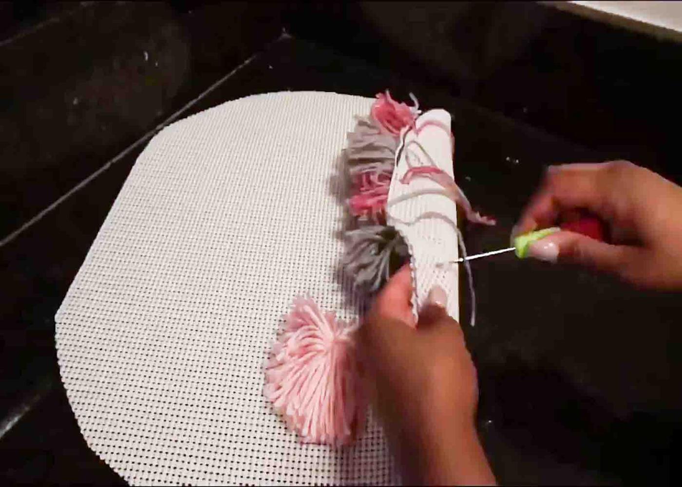Attaching the pompoms to the grip liner.