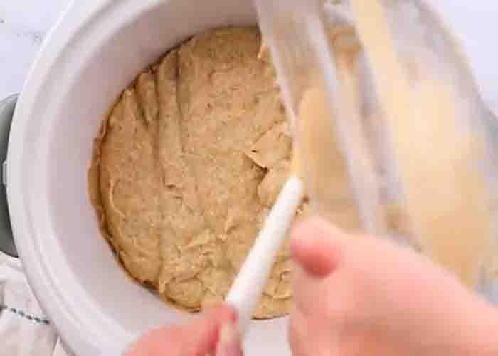 Pouring the banana bread batter into the slow cooker