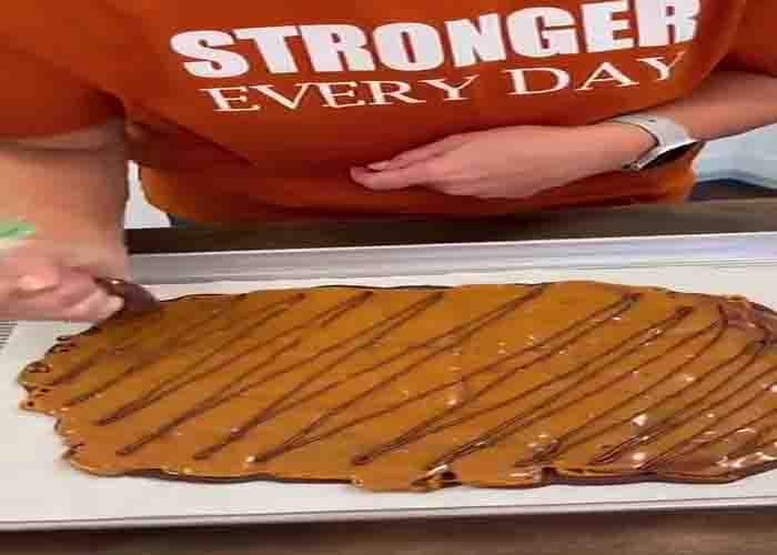 Drizzling some chocolate on top of the caramel pretzel bark