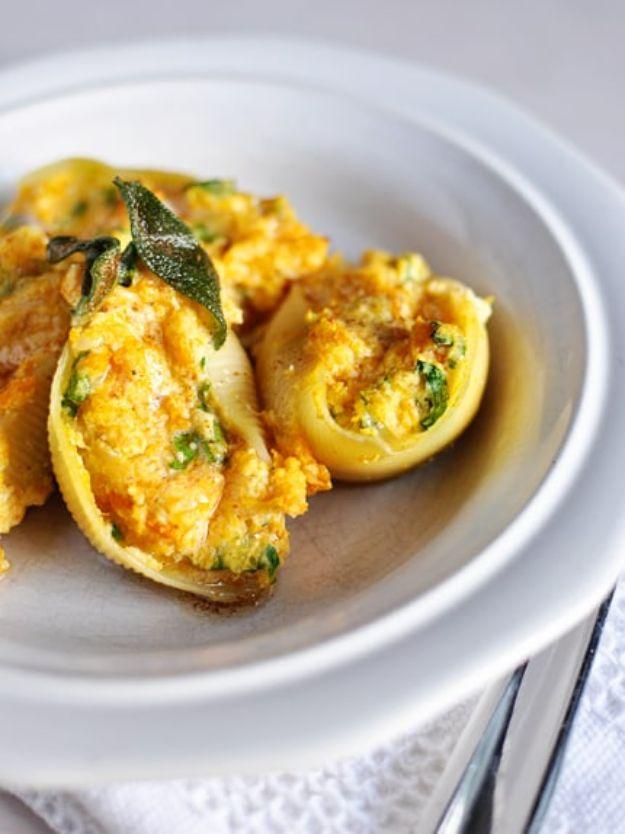 Butternut squash stuffed pasta shells on a white plate with browned butter and crisp fried sage leaves