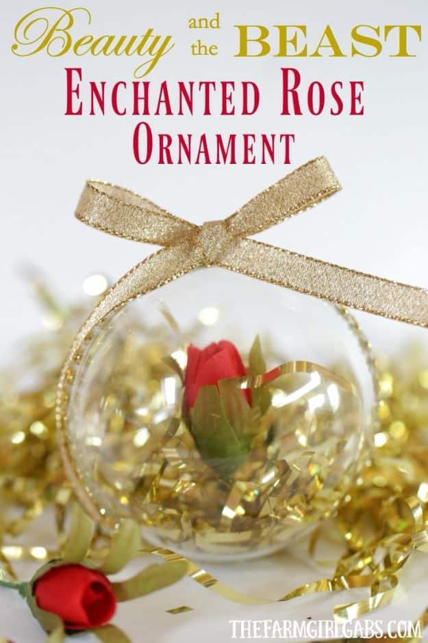 Enchanted rose ornament, a clear ball holding a red rose in gold crinkle filler with a gold ribbon bow