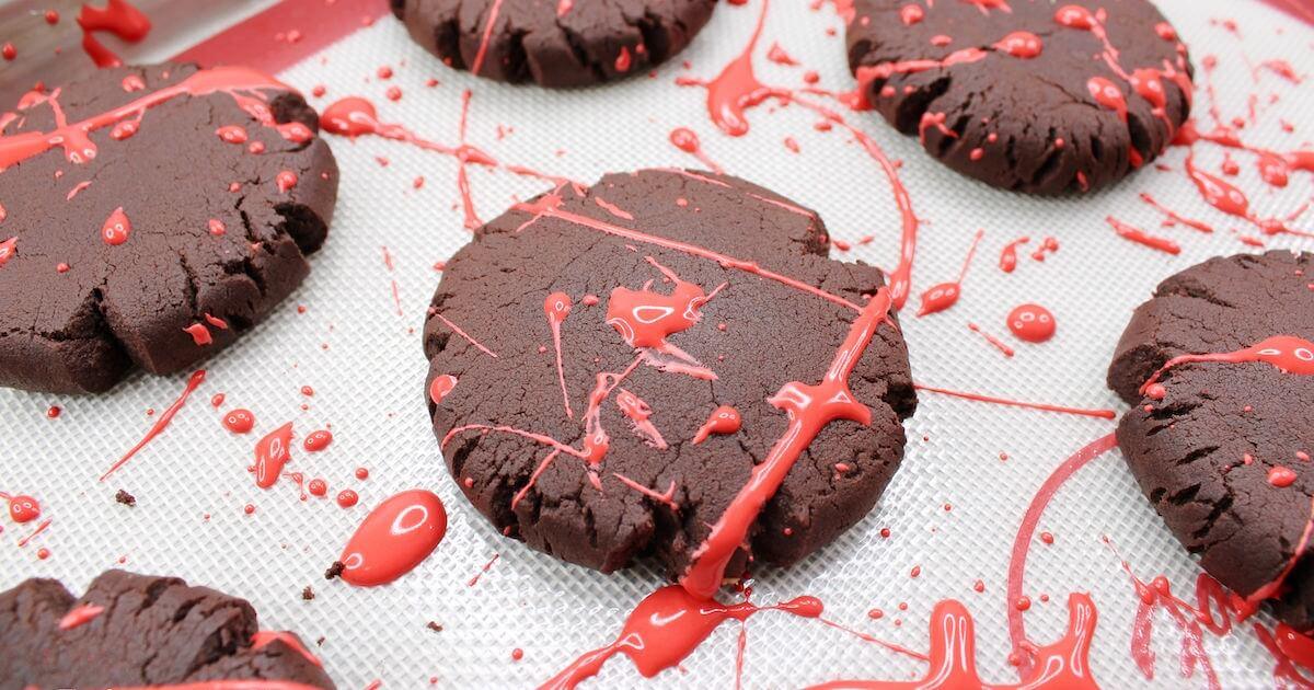 Dark chocolate cookies covered with bright red icing splatters for a dramatic Halloween party treat platter