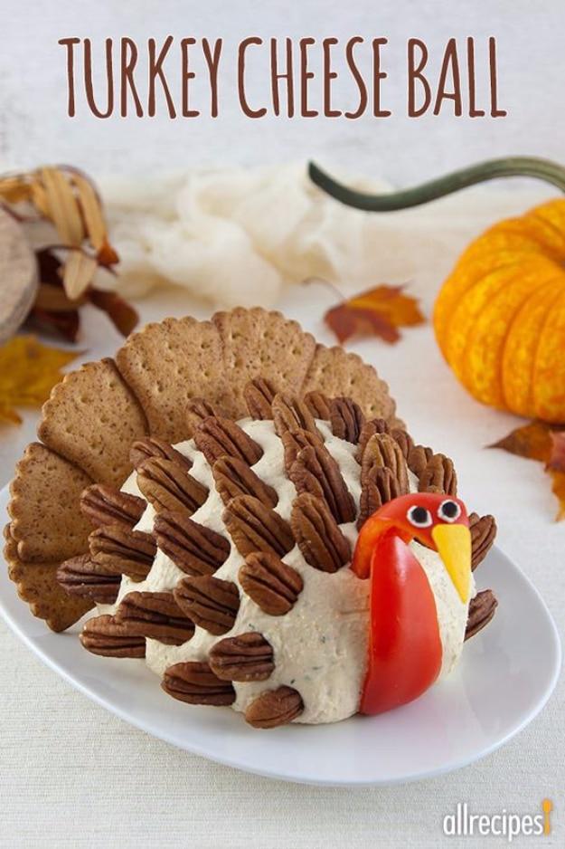 Turkey shaped cheese ball with cracker feathers and a pretzel tail on a platter as a holiday appetizer