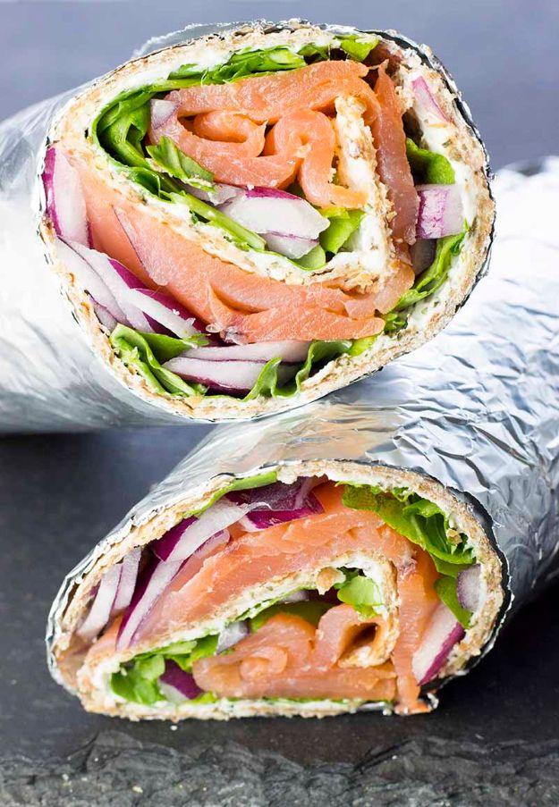 Smoked salmon and cream cheese wrap sliced in half, filled with arugula, red onion and smoked salmon