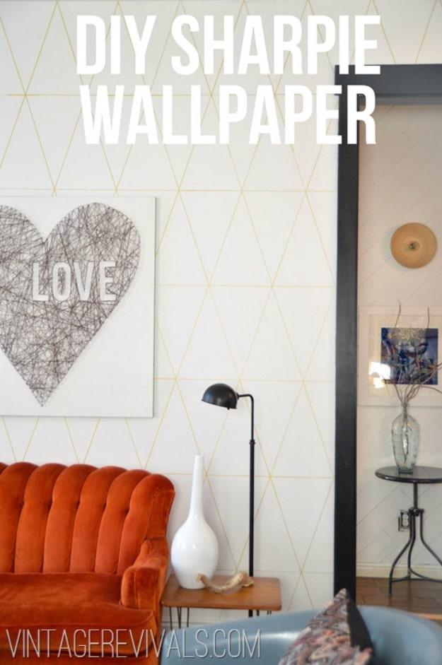 DIY sharpie wallpaper, a white living room wall drawn with a fine gold triangle grid above an orange velvet sofa