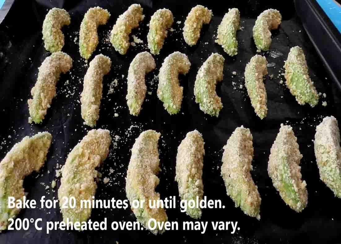 Arranging the coated avocado wedges to the baking tray for baking