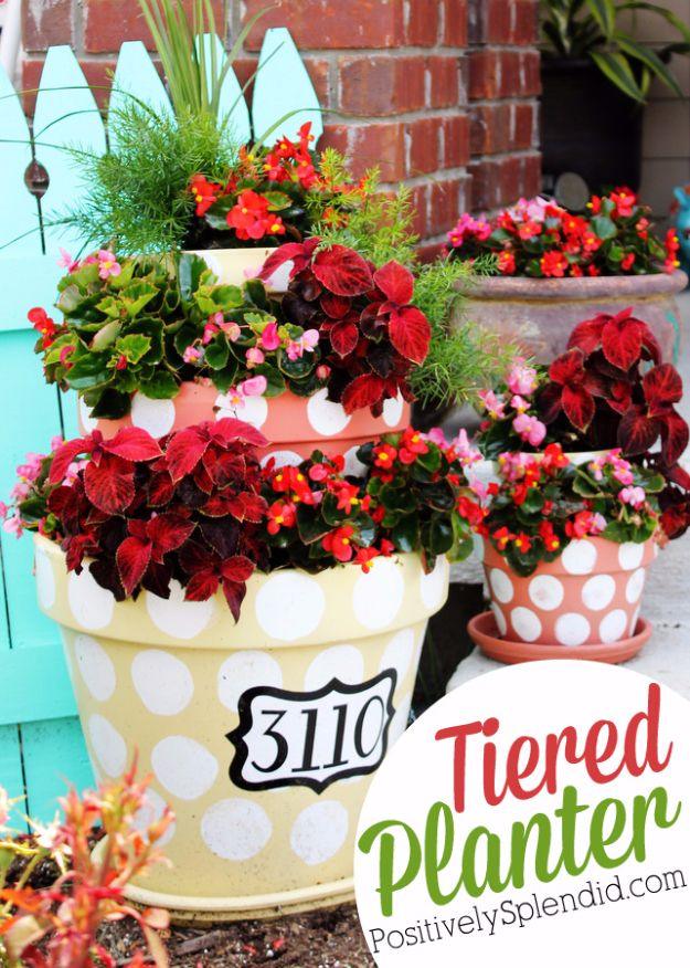 Tiered polka dot planters in cream and coral with red flowers and a house number plate on the bottom pot