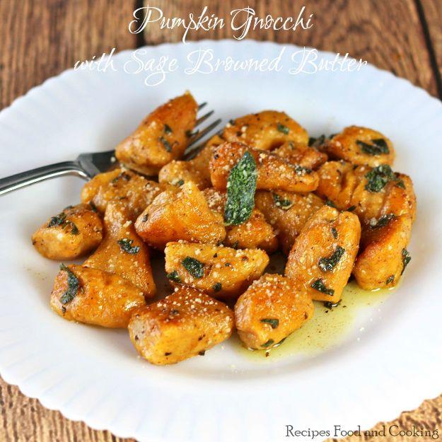 White plate of soft gnocchi in browned butter with crisped sage leaves and a fork resting on the edge