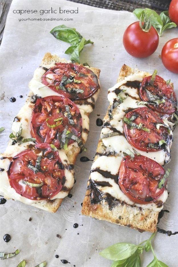 Caprese garlic bread on a split French loaf with melted mozzarella, sliced fresh tomatoes and basil leaves