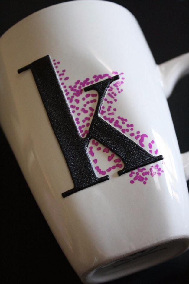 Easy dotted sharpie mugs, a white mug with a black letter K surrounded by a cloud of tiny magenta and purple dots