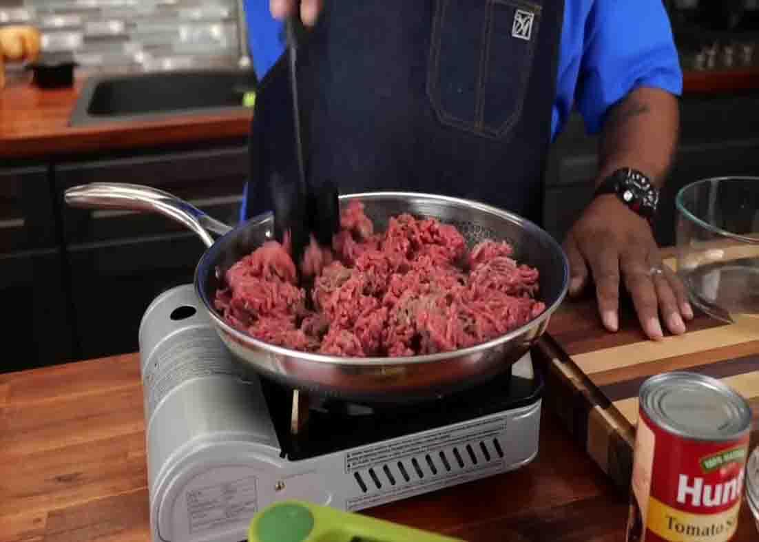 Breaking up the ground beef for the beef noodle casserole