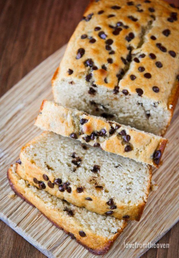 Chocolate chip loaf sliced on a wooden board, chocolate chips scattered through the pale crumb of every slice