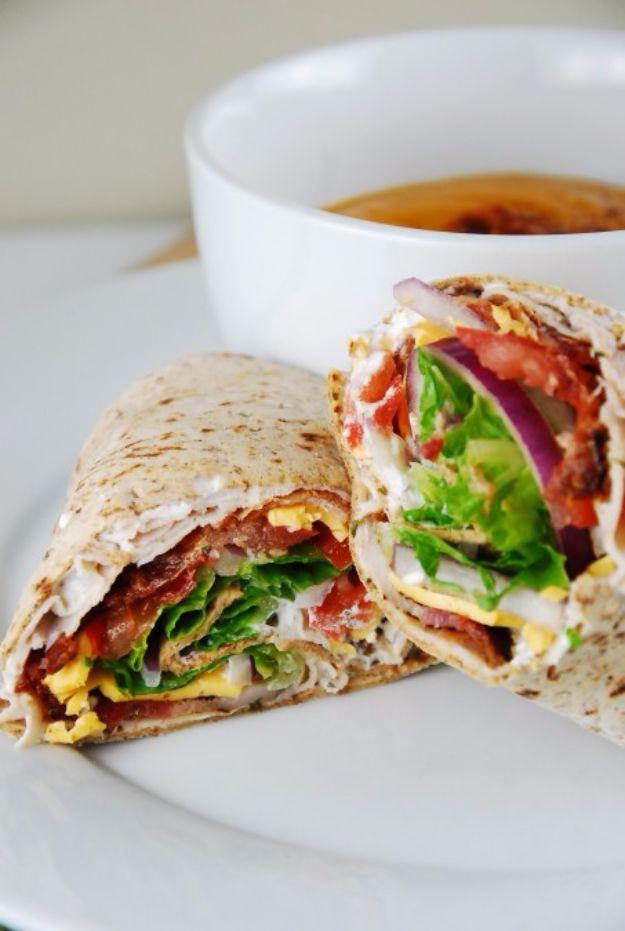 Bacon ranch turkey wrap cut in half showing turkey, bacon, cheese, lettuce and tomato in a light flatbread