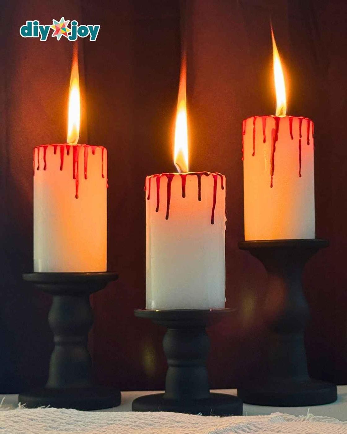 Close up of a bloody candle showing realistic red wax blood drips made from melted crayons, a gothic Halloween decoration.
