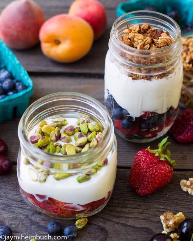 Yogurt parfaits in a mason jar with layers of yogurt, fresh fruit and granola ready for breakfast on the go