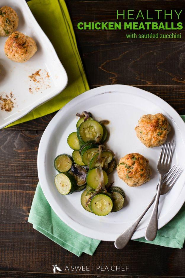 Healthy chicken meatballs, golden baked ground chicken meatballs on a white plate with sauteed zucchini slices