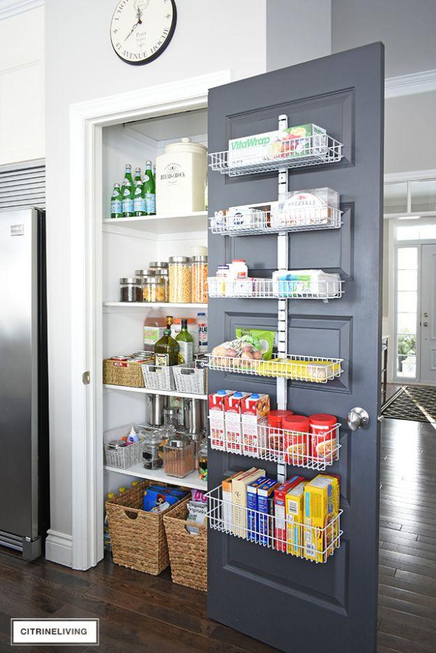 Dark grey pantry door fitted with five white wire racks holding boxes and bottles, white shelves and jars behind