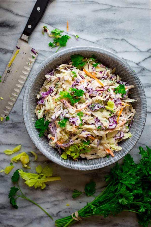 Skinny classic coleslaw, creamy pale slaw with purple cabbage and shredded carrot in a grey bowl with a chef knife
