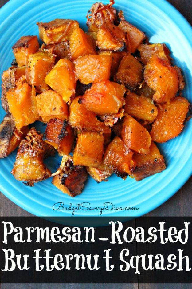 Parmesan roasted butternut squash cubes piled on a bright blue plate with browned crisp cheesy edges