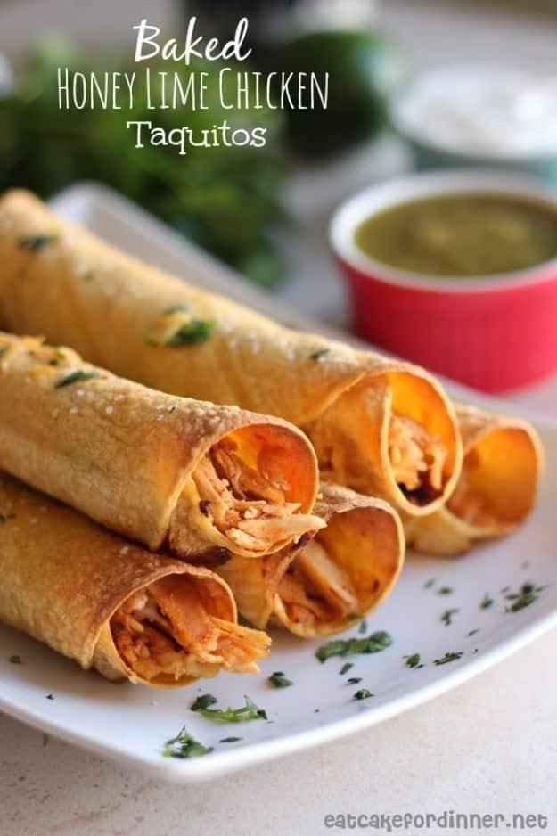 Baked honey lime chicken taquitos rolled on a foil lined sheet pan with green chile sour cream for dipping