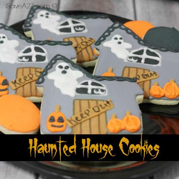 House-shaped Halloween cookies decorated with colorful icing ghosts, windows, pumpkins and a retained source watermark