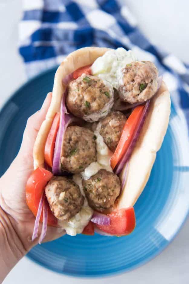 Baked Greek feta meatballs tucked into warm pita bread with sliced tomato, red onion and tzatziki sauce