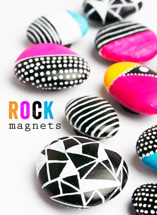 Painted rock magnets in hot pink, black, white and turquoise with dot and stripe patterns, on a white background