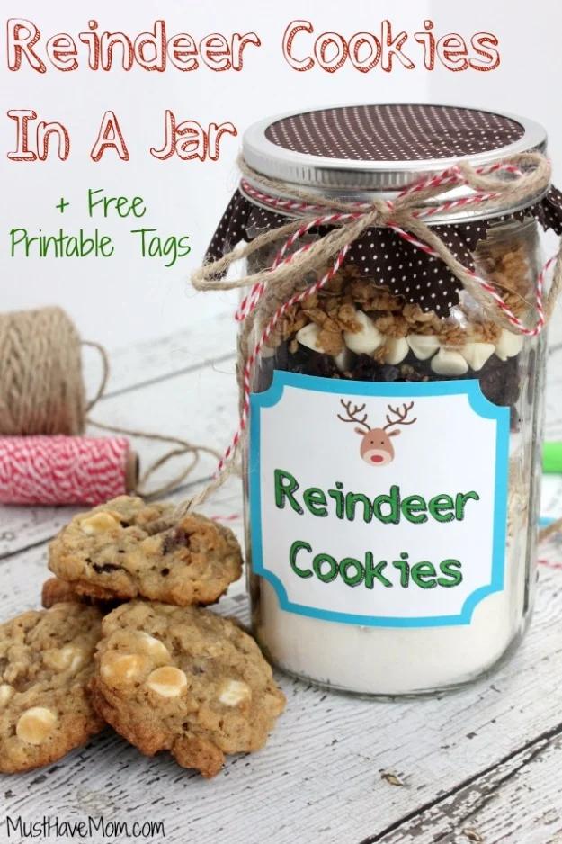 Reindeer cookies in a jar gift with layered cookie mix, a reindeer label and baked cookies beside it