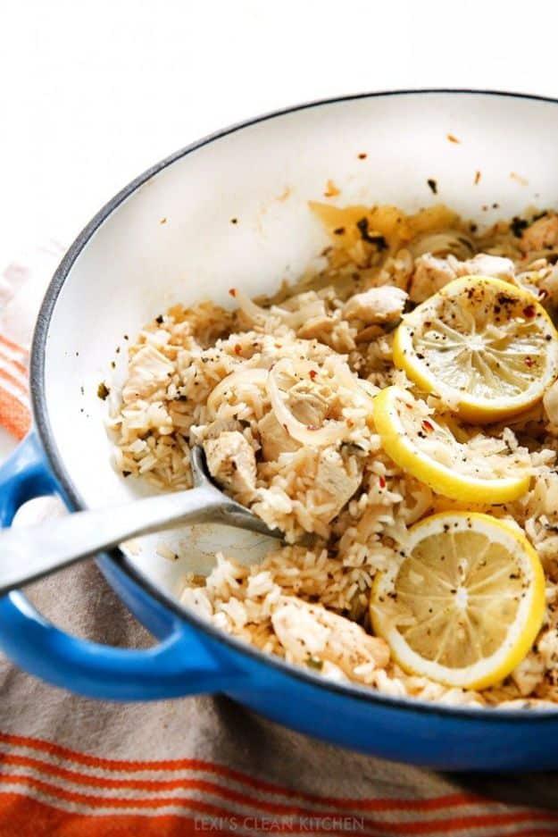 Lemon garlic chicken and rice in a blue enameled pan with rice, chicken pieces and pale lemon slices on top